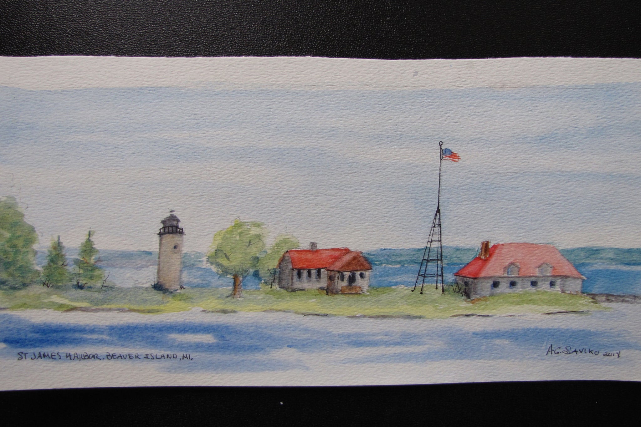 A watercolor painting of the St. James Harbor Lighthouse on Beaver Island, featuring the lighthouse tower and surrounding buildings with trees in the background.